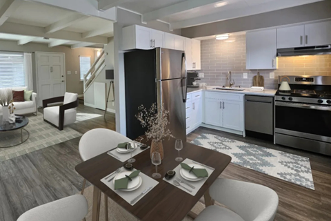 A modern kitchen with a dining table set for two.