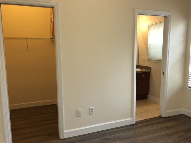 A room with a white wall and a wooden floor.