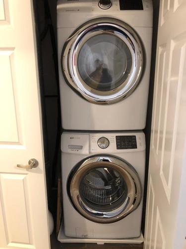 A white washing machine and dryer stacked on top of each other in a small space.