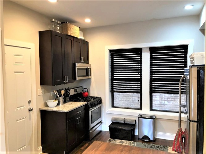 A kitchen with black cabinets and a black stove top.
