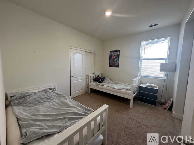 A bedroom with a white bed and a white dresser.