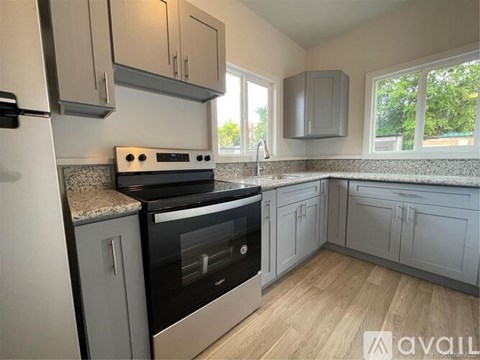 A kitchen with a black oven and a white fridge.