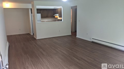 A room with wooden flooring and a white wall.