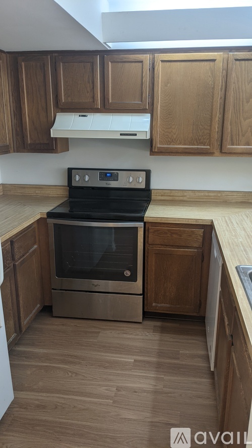 A kitchen with wooden cabinets and a stainless steel oven.