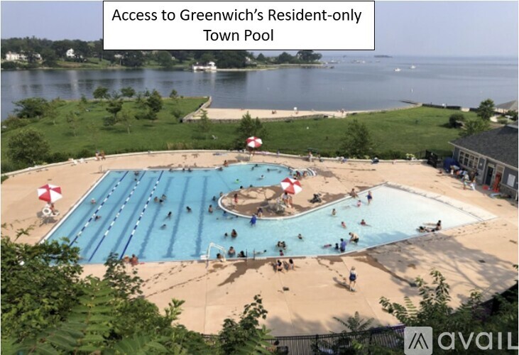 A large swimming pool with people in it and a sign that says "Access to Greenwich's Resident-only Town Pool".