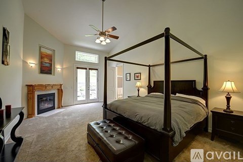 A bedroom with a large bed and a fireplace.