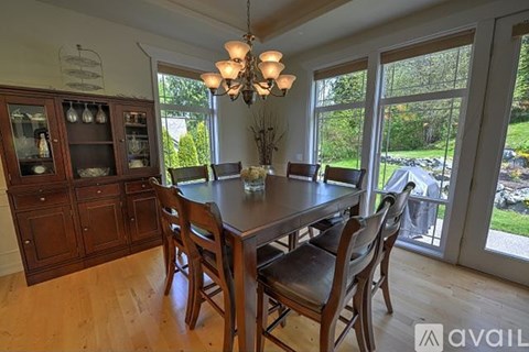 A dining room with a wooden table and chairs.