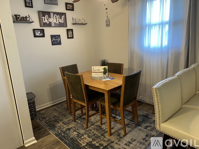 A dining room with a wooden table and chairs.