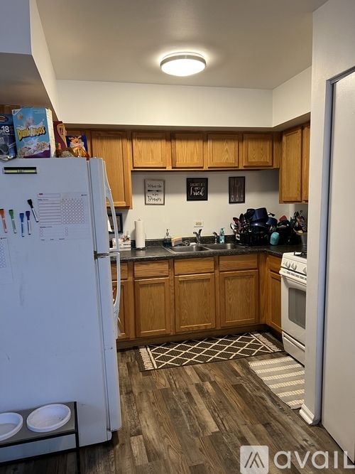 A kitchen with wooden cabinets and a white refrigerator.