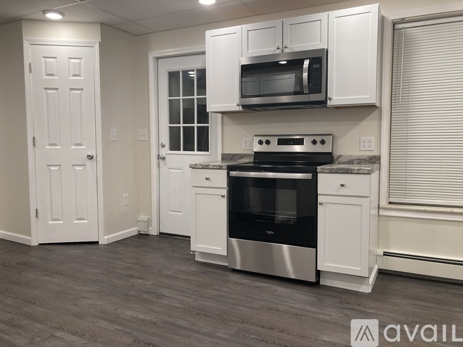 A kitchen with white cabinets and a stainless steel oven.
