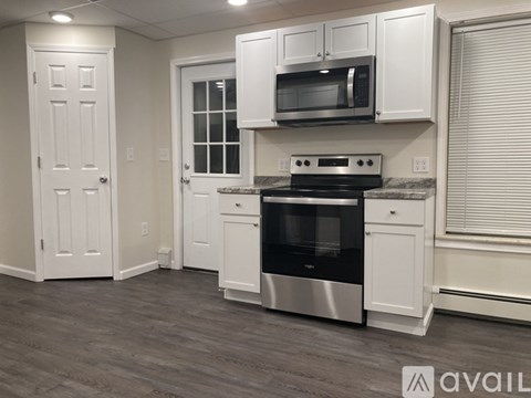 A kitchen with white cabinets and a stainless steel oven.