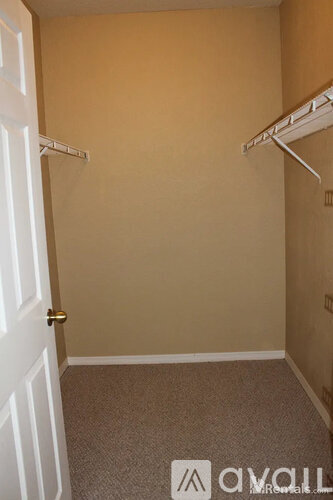 A bedroom with a carpeted floor and a white door.
