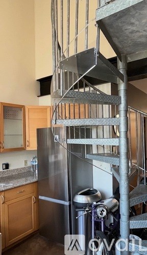 A stainless steel refrigerator in a kitchen with wooden cabinets.