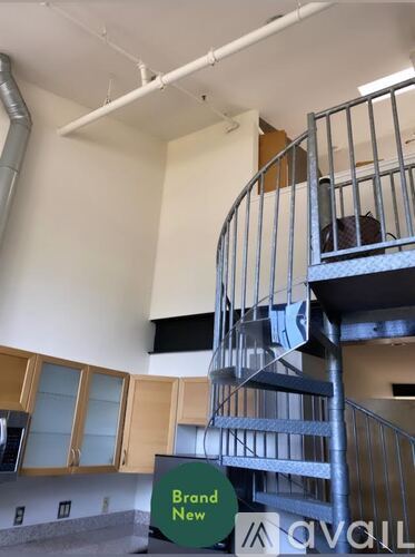 A spiral staircase in a building with a sign that says "Brand New".
