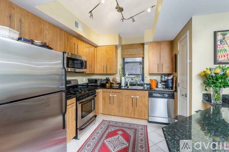 A kitchen with wooden cabinets and a stainless steel refrigerator.