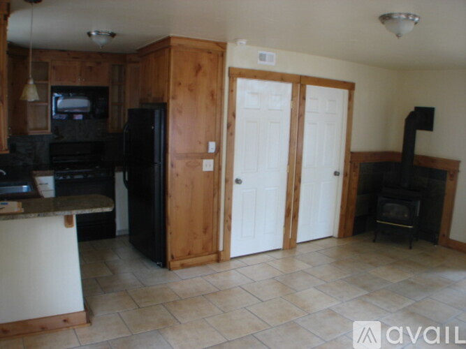 A kitchen with a black refrigerator and a black stove top oven.