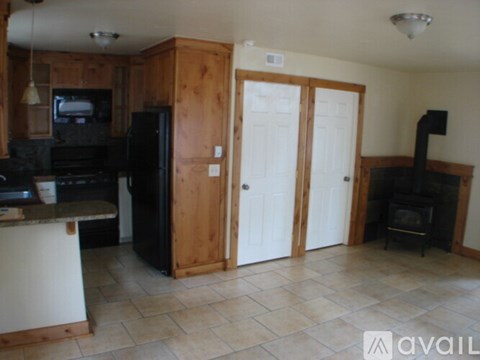 A kitchen with a black refrigerator and a black stove top oven.