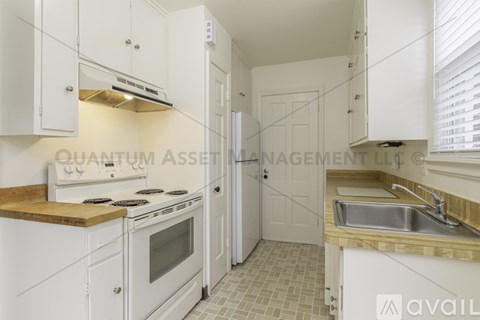 A kitchen with white cabinets and a wooden countertop.