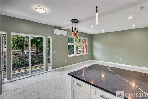 A kitchen with a marble countertop and white cabinets.