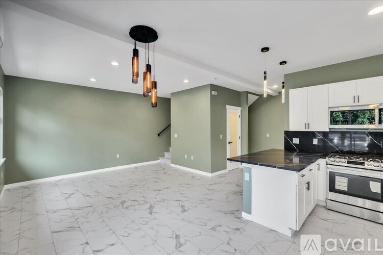A kitchen with a marble floor and a black and white stove top oven.