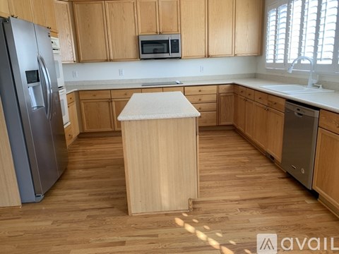 A kitchen with wooden cabinets and a white island.