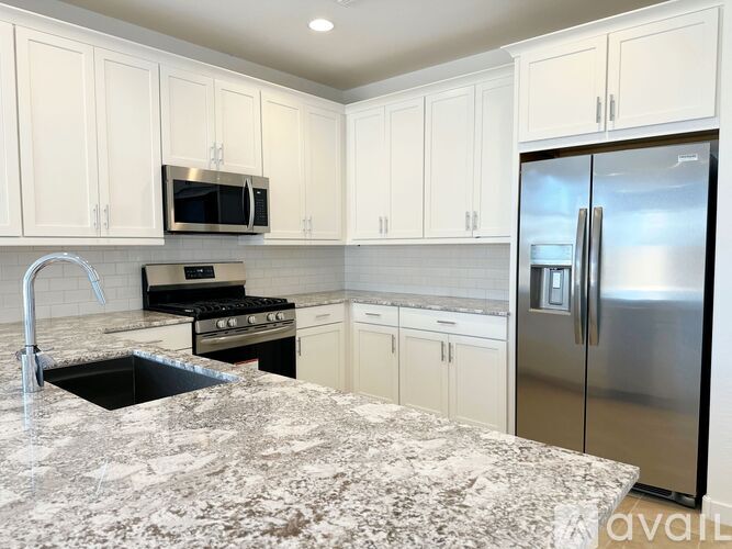 A kitchen with granite countertops and stainless steel appliances.
