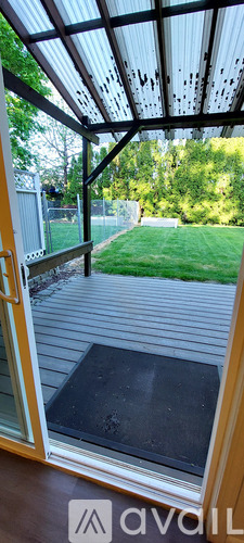 A patio with a door and a view of a grassy area.