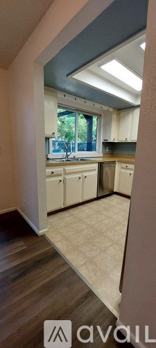 A kitchen with white cabinets and a window.