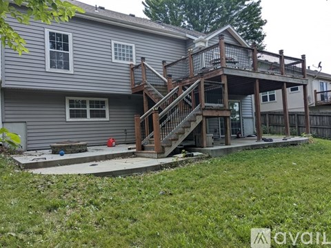 A house with a deck and stairs leading to the second floor.