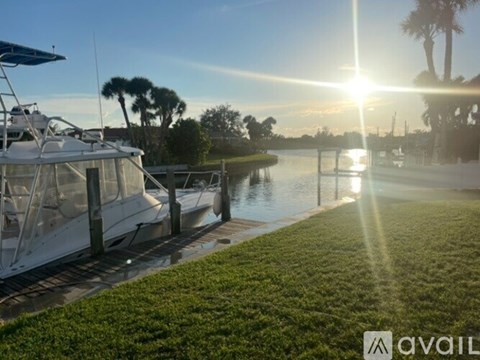 A sunny day at the marina with boats docked and palm trees in the background.