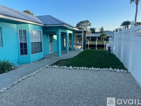 A blue house with a white picket fence in front.