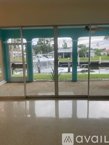 A room with a view of a marina through a sliding glass door.