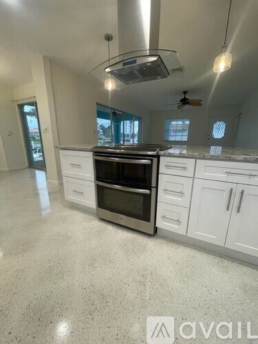 A modern kitchen with white cabinets and a central island.