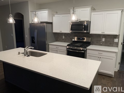 A kitchen with white cabinets and a granite countertop.