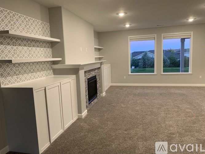 A living room with a fireplace and two windows.