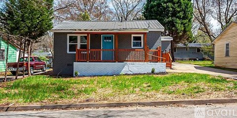 A small house with a blue door and a red railing.