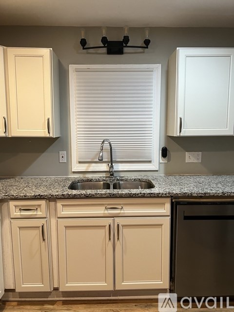 A kitchen with white cabinets and a granite countertop.