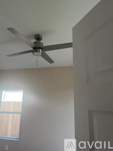 A ceiling fan is hanging from the ceiling in a room.