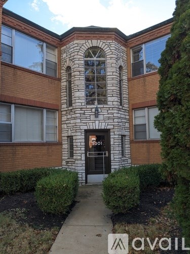 A building with a stone pillar in front and a black door.