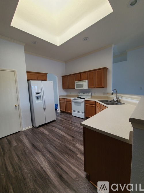 A kitchen with wooden cabinets and a white counter.