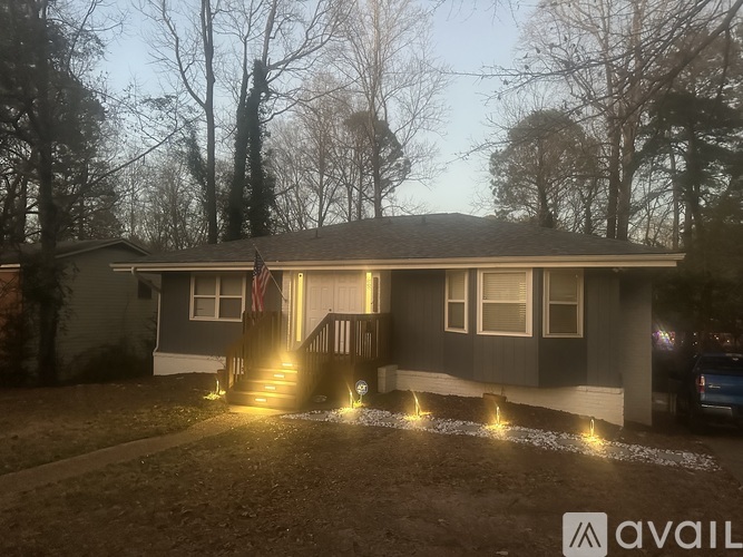 A house with a flag on the front porch is lit up with lights.