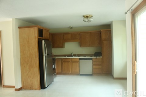 A kitchen with wooden cabinets and a black refrigerator.