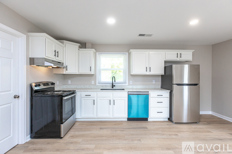 A kitchen with white cabinets and a black stove top oven.