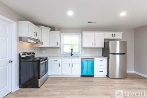 A kitchen with white cabinets and a black stove top oven.