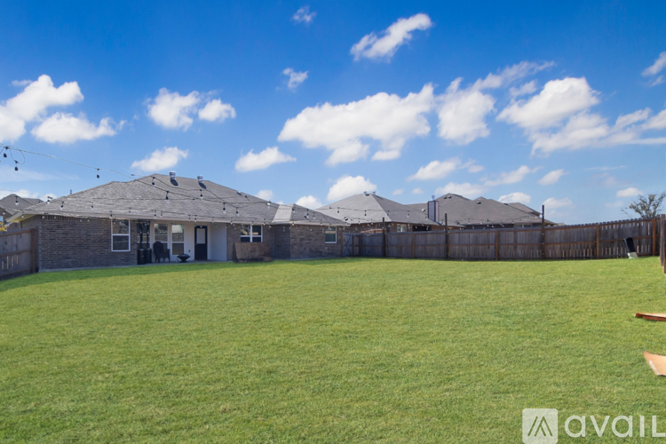 A large grassy field with a building in the background.