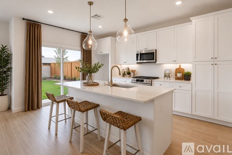 A kitchen with white cabinets and a large island with bar stools.