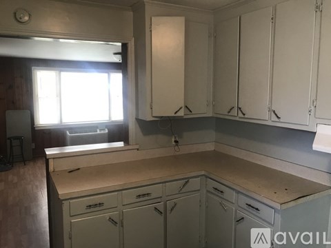 A kitchen with white cabinets and a wooden countertop.