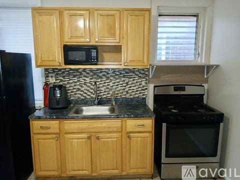 A kitchen with wooden cabinets and black appliances.