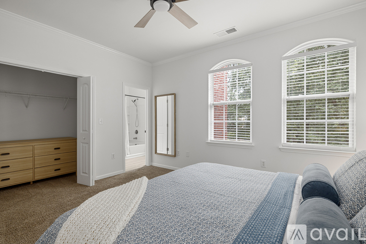 A bedroom with a large bed and a ceiling fan.