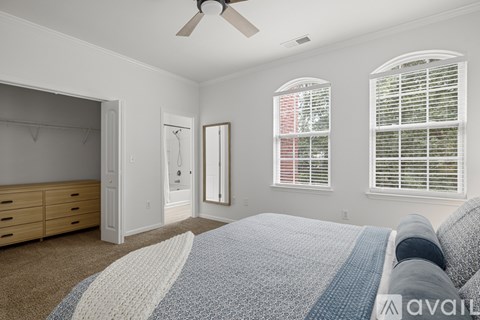 A bedroom with a large bed and a ceiling fan.
